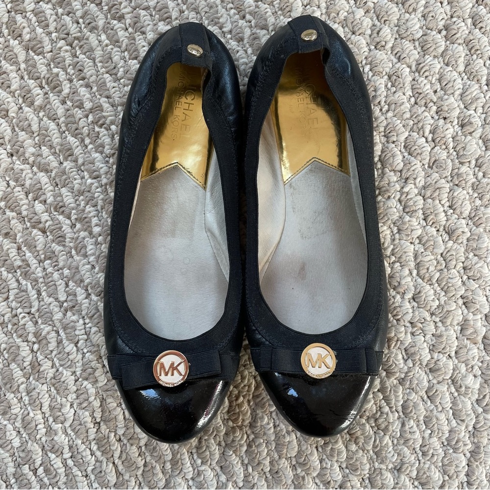 Stretchy black Michael Kors flat with gold emblem